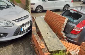 Circula sin carné en Pamplona y choca contra un muro que cae sobre un vehículo estacionado